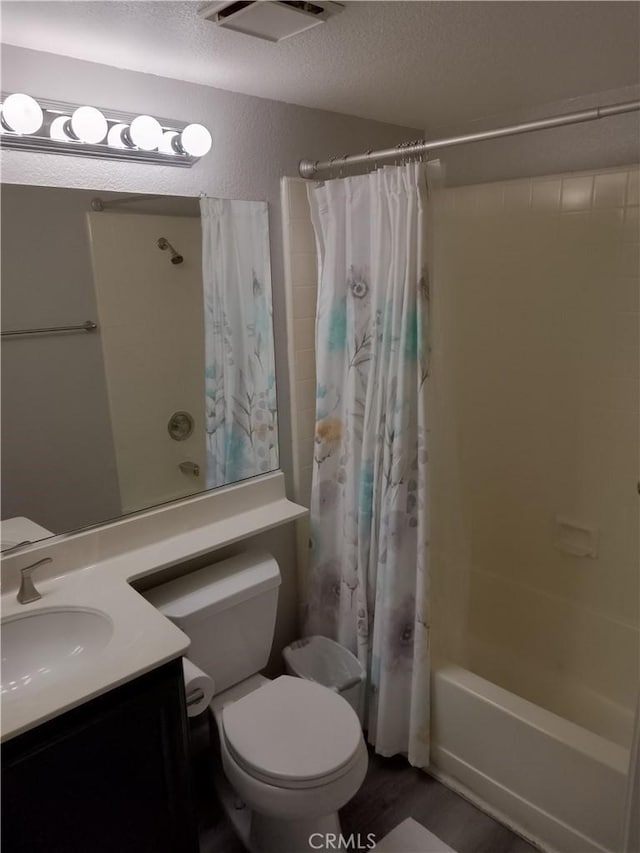 bathroom with visible vents, toilet, shower / tub combo, a textured ceiling, and vanity