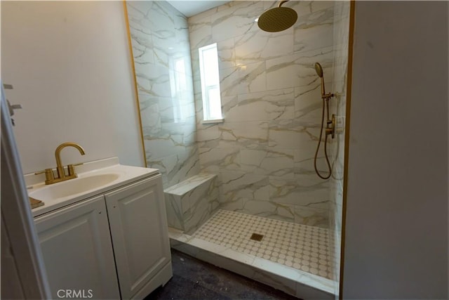 bathroom with a marble finish shower and vanity