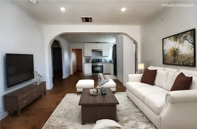 living room featuring visible vents, ornamental molding, recessed lighting, wood finished floors, and arched walkways