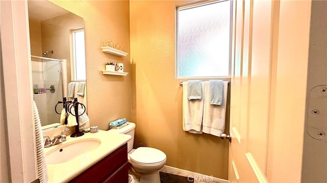 full bathroom with a shower with door, vanity, and toilet