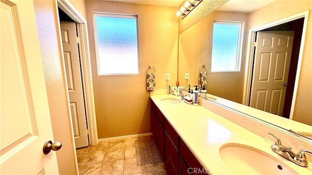 bathroom with a healthy amount of sunlight, a sink, and double vanity