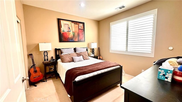 bedroom with visible vents and light carpet