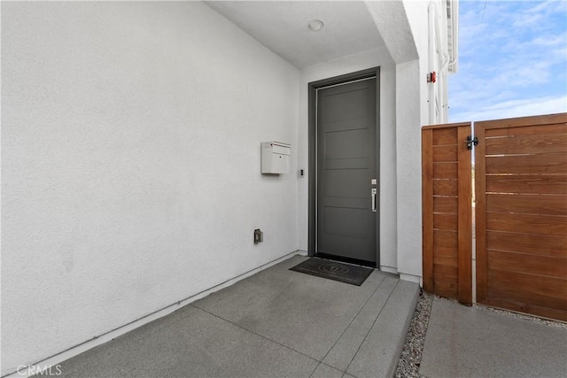 doorway to property featuring stucco siding