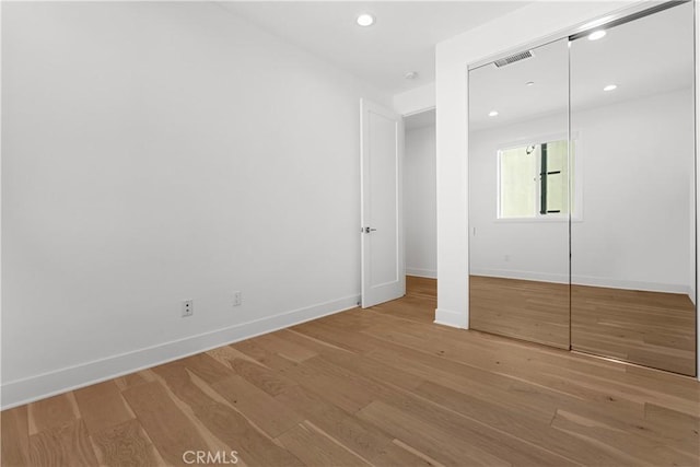 unfurnished bedroom with light wood finished floors, visible vents, and baseboards