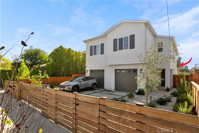 view of property exterior with concrete driveway, a garage, and fence