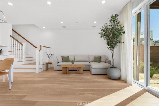 living room featuring recessed lighting, a healthy amount of sunlight, and stairs