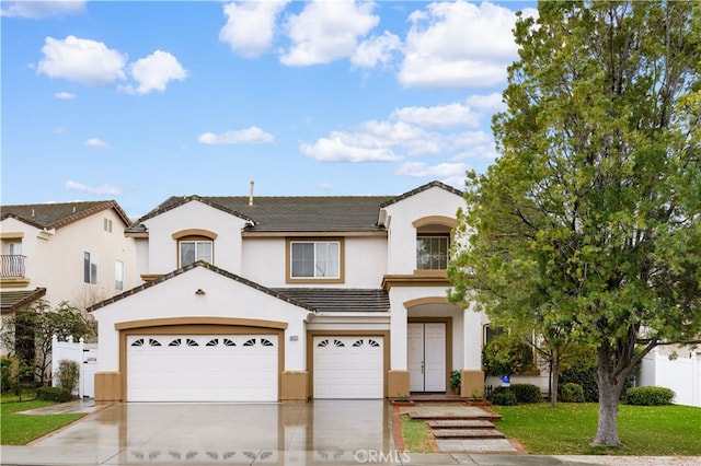 view of front of property featuring fence, driveway, stucco siding, a front lawn, and a tile roof