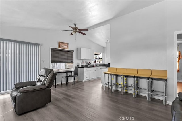 living room featuring a ceiling fan, lofted ceiling, dark wood finished floors, and baseboards