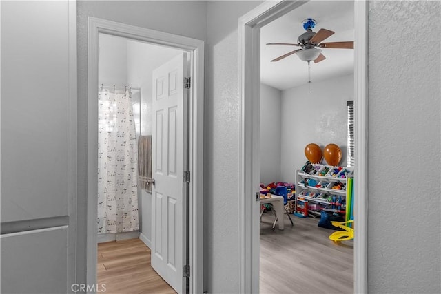 corridor featuring a textured wall and wood finished floors