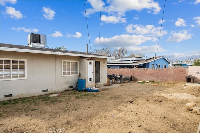 back of property featuring roof with shingles, crawl space, fence, central air condition unit, and stucco siding