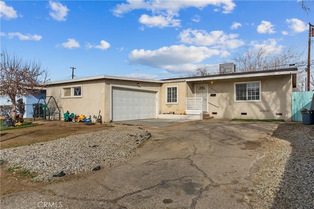 ranch-style house featuring a garage, driveway, crawl space, and stucco siding