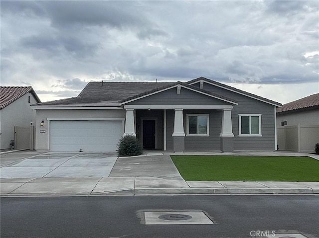 view of front facade featuring an attached garage, fence, concrete driveway, and a front yard