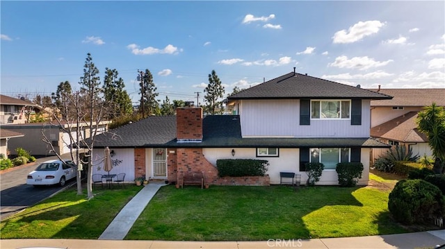 traditional-style house with a chimney and a front lawn