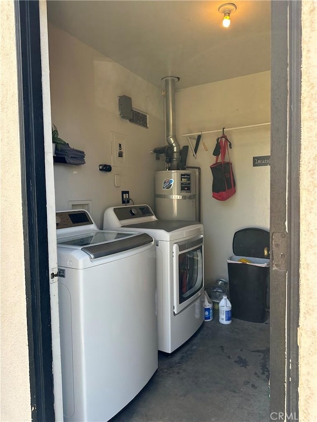 washroom featuring washing machine and dryer, laundry area, and water heater