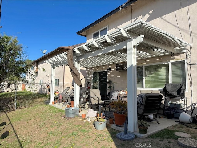 rear view of property featuring a yard, stucco siding, fence, and a pergola