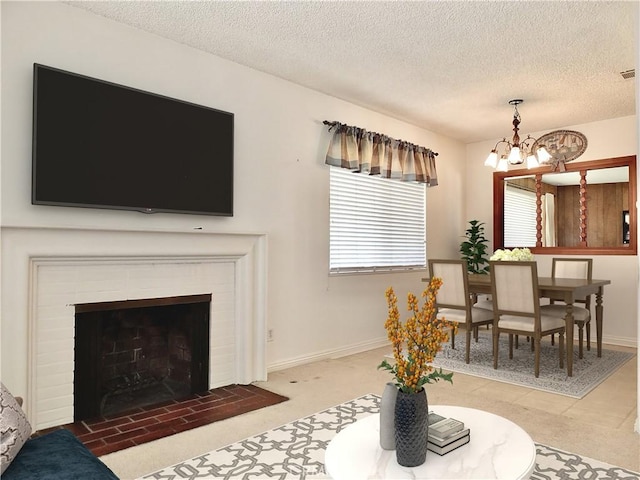 living area with a notable chandelier, a fireplace, a textured ceiling, and baseboards