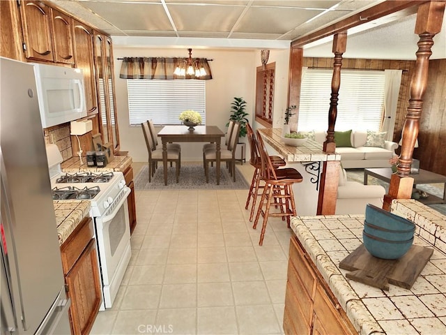 kitchen featuring tile countertops, white appliances, and brown cabinets