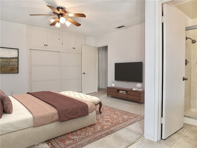 bedroom with ceiling fan, visible vents, and a textured ceiling