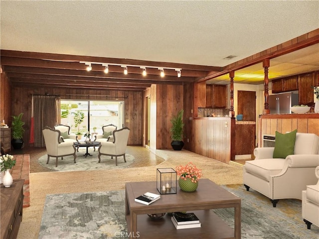 living area with carpet, wood walls, and a textured ceiling