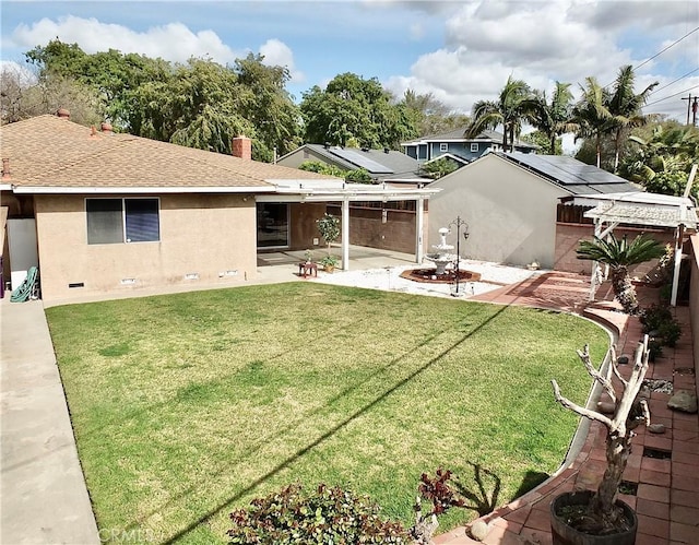 rear view of property featuring a patio, a shingled roof, stucco siding, crawl space, and a lawn