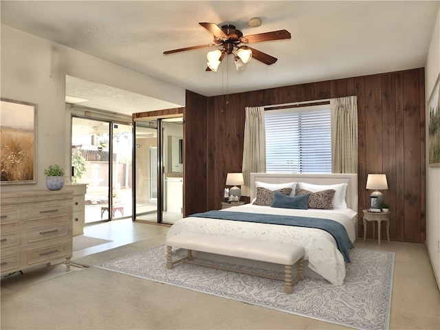 bedroom with light carpet, wood walls, and a ceiling fan