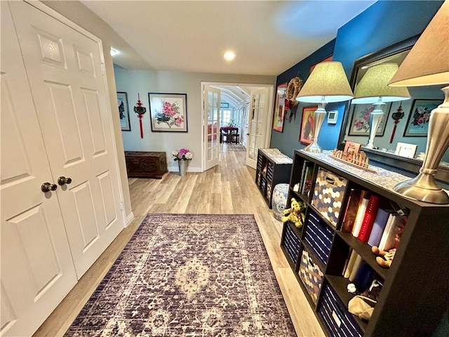 hallway featuring recessed lighting, french doors, baseboards, and wood finished floors