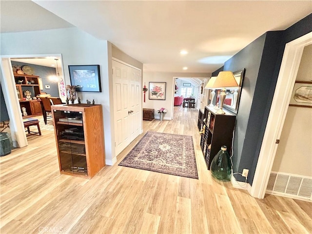 corridor featuring light wood-style floors, visible vents, and baseboards