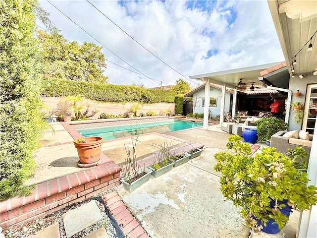 view of pool featuring a patio area, a fenced backyard, a fenced in pool, and a ceiling fan