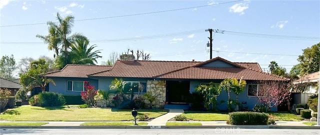 view of front of home featuring stucco siding, a front lawn, and a tiled roof