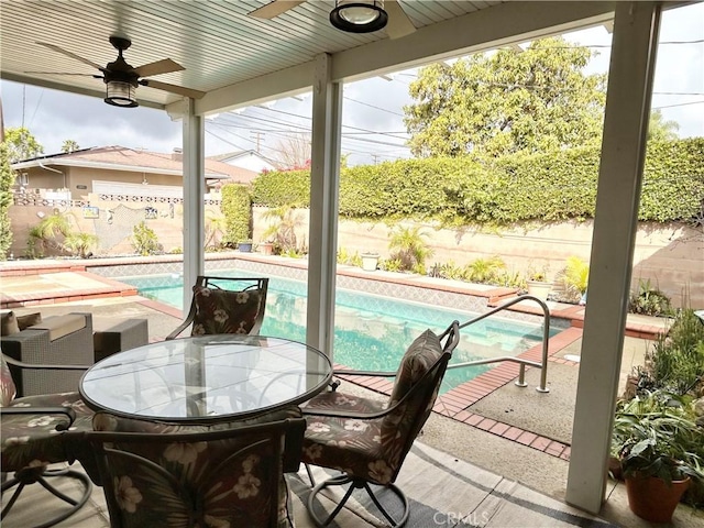 sunroom featuring a healthy amount of sunlight, ceiling fan, and a swimming pool