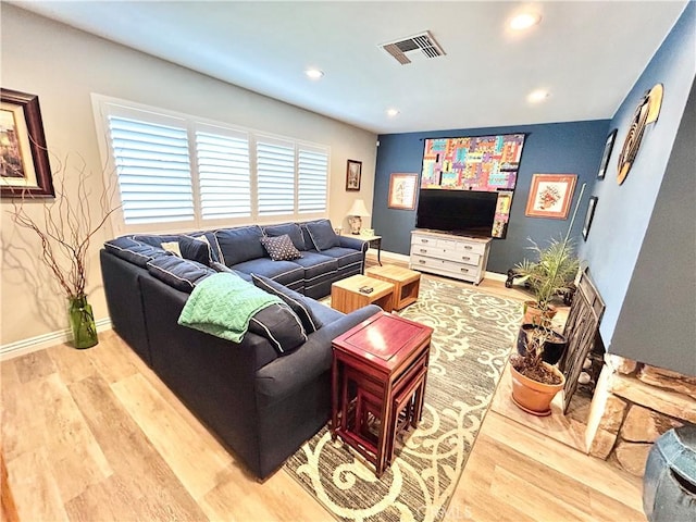 living room with recessed lighting, visible vents, and wood finished floors