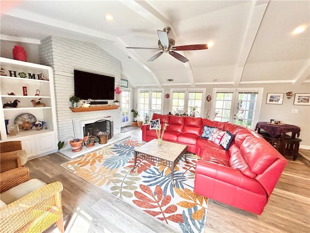 living area featuring plenty of natural light, french doors, vaulted ceiling, and wood finished floors