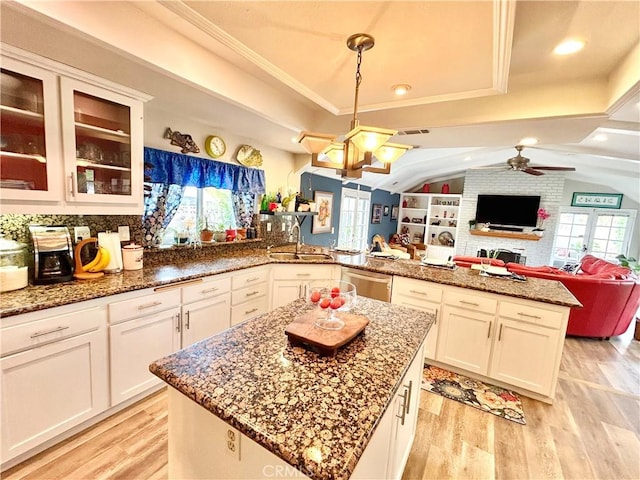 kitchen with light wood-style floors, open floor plan, a sink, and stainless steel dishwasher