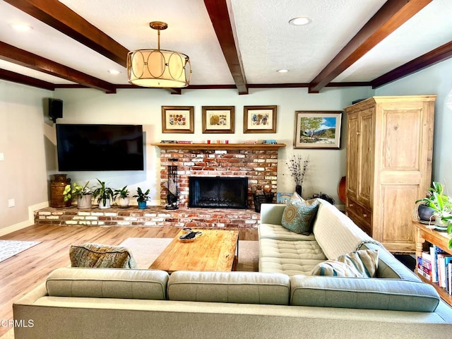 living room featuring a fireplace, recessed lighting, a textured ceiling, wood finished floors, and baseboards