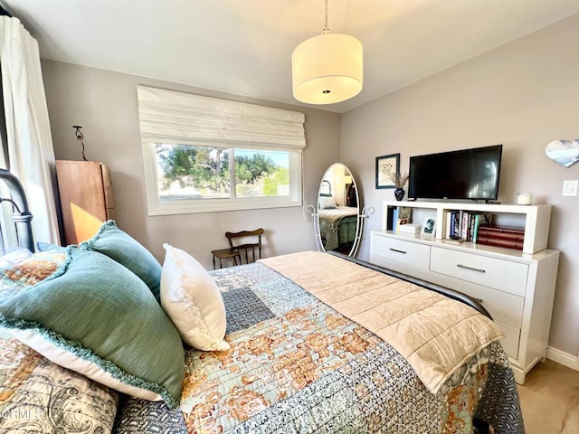 bedroom featuring light carpet and baseboards