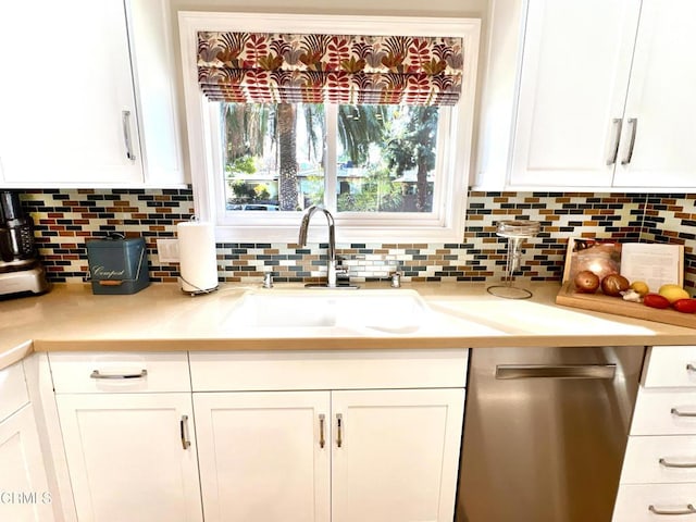 kitchen featuring light countertops, white cabinets, a sink, and stainless steel dishwasher