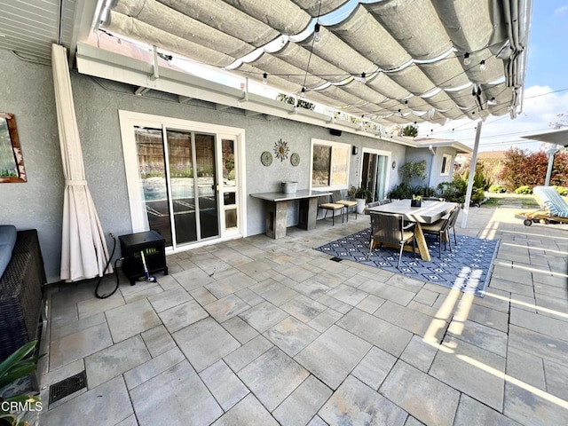 view of patio featuring outdoor dining area, visible vents, and a pergola