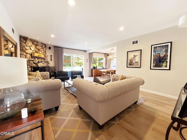 living room featuring light wood finished floors, recessed lighting, visible vents, and baseboards