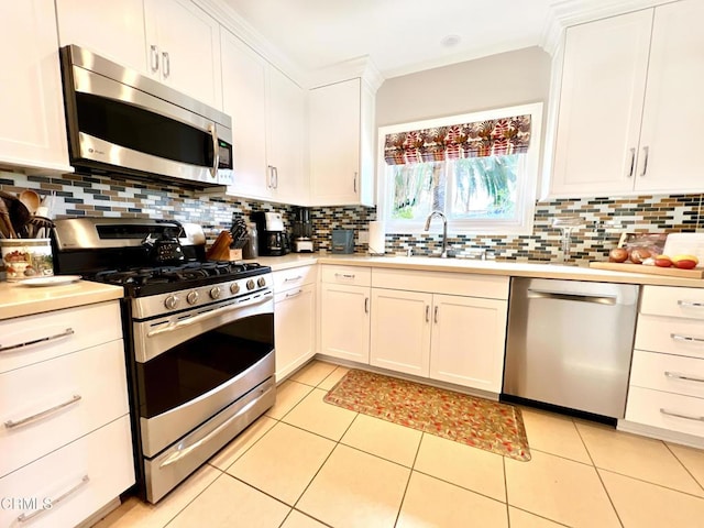 kitchen with backsplash, appliances with stainless steel finishes, light countertops, and a sink