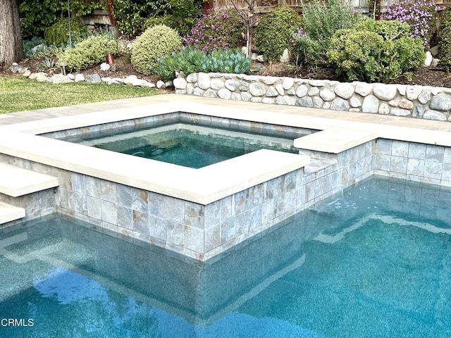 view of swimming pool with an in ground hot tub