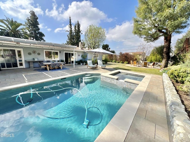 outdoor pool with an in ground hot tub and a patio area