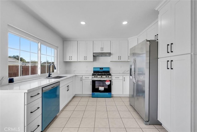 kitchen featuring white cabinets, appliances with stainless steel finishes, light countertops, under cabinet range hood, and a sink