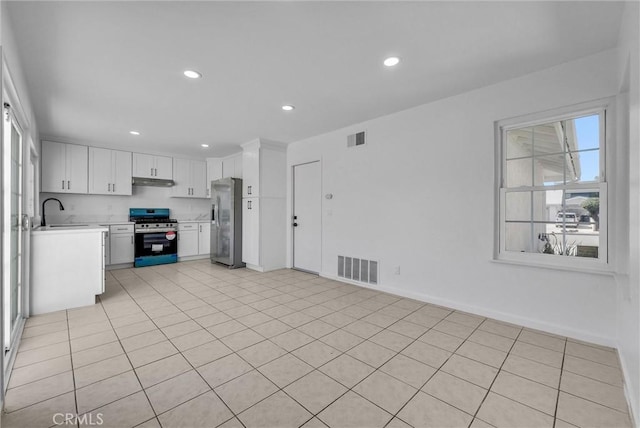 kitchen with stainless steel appliances, a sink, visible vents, and under cabinet range hood