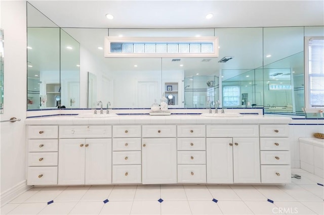 full bath with double vanity, plenty of natural light, a sink, and a shower stall