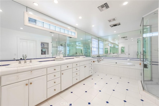 bathroom with a garden tub, a sink, visible vents, double vanity, and a stall shower