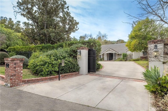 exterior space featuring fence, concrete driveway, and stucco siding