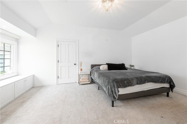 bedroom featuring light carpet, lofted ceiling, and baseboards