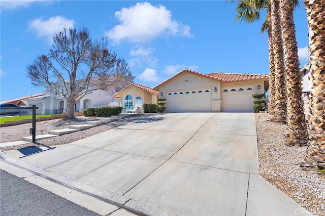 mediterranean / spanish-style home with concrete driveway, an attached garage, a tile roof, and stucco siding