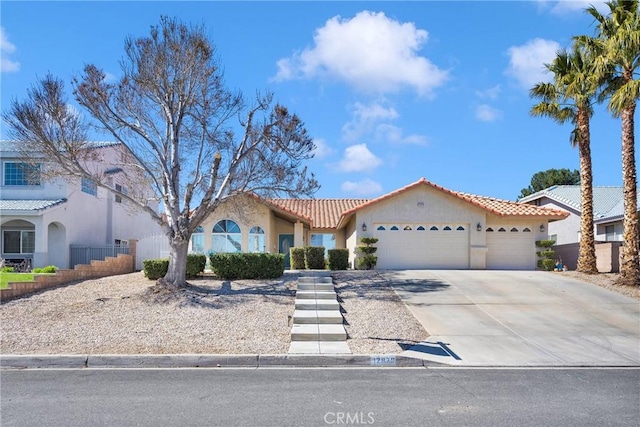 mediterranean / spanish home featuring a garage, driveway, a tile roof, fence, and stucco siding