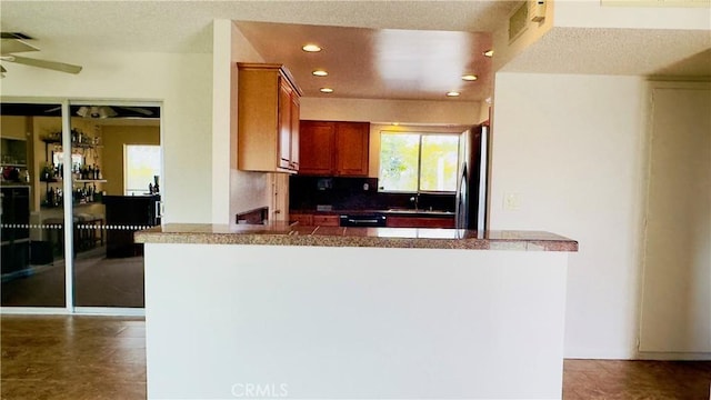 28821 Del Monte Dr, Menifee, CA 92586 - kitchen featuring freestanding refrigerator, a ceiling fan, recessed lighting, tile counters, and brown cabinets